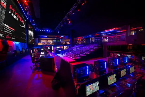 Arena floor with gaming stations under purple stage lighting